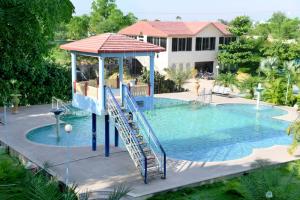a swimming pool with a slide in the middle of it at Hotel Rani Bagh Resort in Beāwar