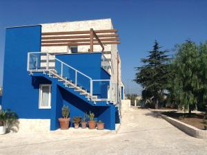 a blue building with a staircase and potted plants at Bed and Breakfast Fly in Bari