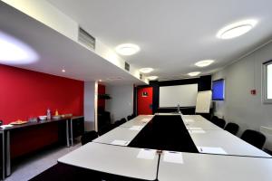 a conference room with a white table and a screen at initial by balladins Amiens / Longueau in Longueau