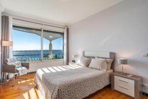 フンシャルにあるOceanside Terrace Apartment by HR Madeiraの白いベッドルーム(ベッド1台、大きな窓付)