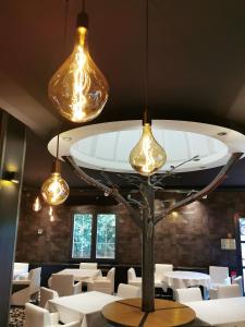a dining room with white tables and lights at Le Grand Hôtel Le Touquet-Paris-Plage in Le Touquet-Paris-Plage