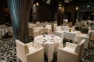 a dining room with white tables and white chairs at Le Grand Hôtel Le Touquet-Paris-Plage in Le Touquet-Paris-Plage +37 photos