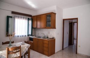 a kitchen with wooden cabinets and a table with a dining room at Maxis apartment 2 in Koroni