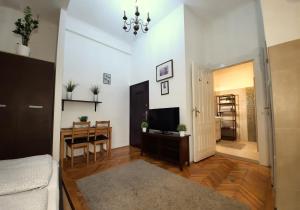 een woonkamer met een tafel en een televisie bij Central Gold Apartment in Boedapest