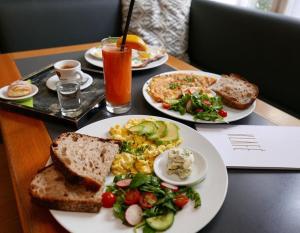 a table with plates of breakfast food on it at Bed&Breakfast & Apartment Klafé in Brno
