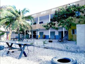 una mesa y sillas frente a un edificio en Auberge Cœur Océan, en Joal-Fadiout