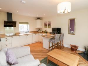 cocina y sala de estar con sofá y mesa en Tight Lyne Cottage, en Carlisle