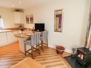 una cucina con tavolo, sedie e fornelli di Tight Lyne Cottage a Carlisle