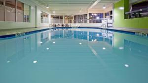 ein Pool mit blauem Wasser in einem Gebäude in der Unterkunft Holiday Inn Burlington Hotel & Conference Centre, an IHG Hotel in Burlington