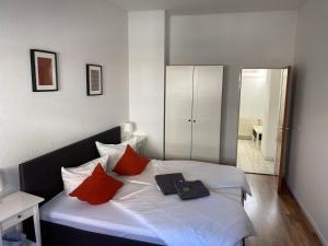 a bedroom with a white bed with red pillows at Pension No.9 in Parchim