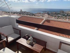 een balkon met een tafel en een stoel op een dak bij Quiet Studio, Incredible views, Climatized pool, FREE WIFI in Arona