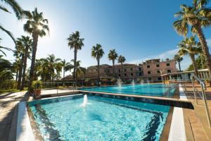 basen z palmami i budynek w obiekcie Orizzonte Acireale Hotel w mieście Acireale