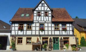 a white and black house with flowers in the windows at Kaiser Wilhelm - Appartement mit Saunanutzung in Burgbernheim
