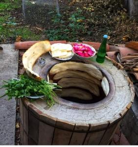 uma mesa com queijo e legumes em cima de um barril em MY HOUSE em Batumi