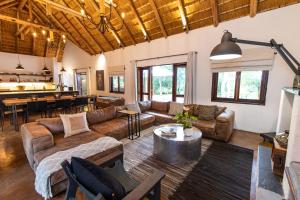 Kingly Bush Villa في بهالابوروا: غرفة معيشة مع كنب وغرفة طعام