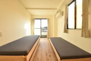 Postel nebo postele na pokoji v ubytování Enzo Tokyo