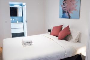 a bedroom with a white bed with red pillows at Smartflats - Bourse Brussels in Brussels