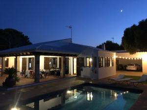 uma casa com piscina à noite em Villa con piscina Cala Morell em Cala Morell