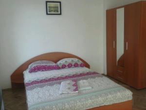 a bedroom with a bed with a wooden head board at Семеен хотел Стаси in Pomorie