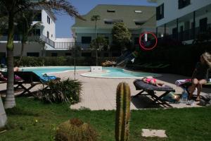 een persoon op een bankje naast een zwembad bij Leme Bedje fronte spiaggia in Santa Maria