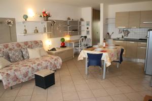 een woonkamer en een keuken met een tafel en een bank bij Leme Bedje fronte spiaggia in Santa Maria