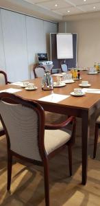 duży drewniany stół z krzesłami i telefonem w obiekcie Stüttgens Hotel w mieście Velbert