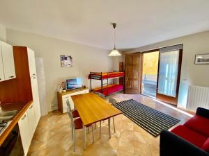 a living room with a table and a bed in a room at Casa Fer La Morra in La Morra