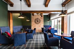 a waiting room with blue chairs and tables at Hotel Almarco in Środa Wielkopolska