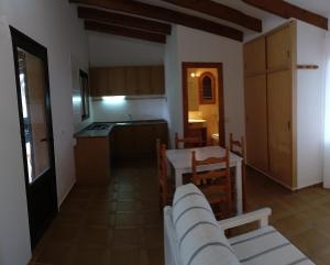 eine Küche und ein Esszimmer mit einem Tisch und Stühlen in der Unterkunft Viviendas Turísticas Vacacionales Allida in Playa Migjorn