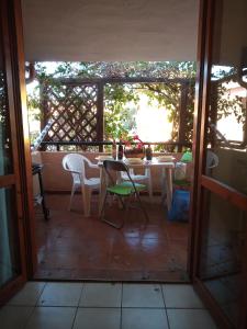 een kamer met een tafel en stoelen op een patio bij La Bouganville in Villasimius