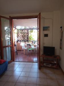 a living room with a door open to a patio at La Bouganville in Villasimius