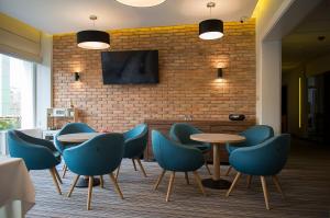 a room with tables and chairs and a brick wall at Hotel Almarco in Środa Wielkopolska