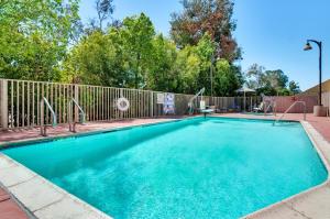 una piscina en un patio con una valla en Holiday Inn Express Hotel & Suites Banning, an IHG Hotel, en Banning