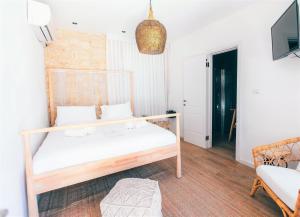 a bedroom with a white bed and a tv at Hotel Anilevich Mansion in Beer Sheva