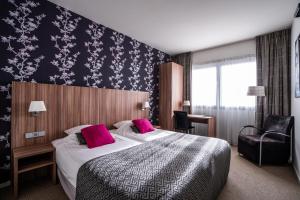 a hotel room with a bed and a chair at Martini Hotel in Groningen