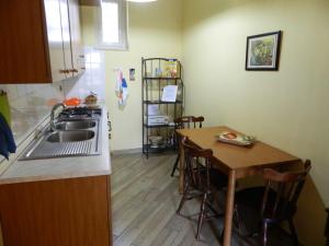 
a kitchen with a table and a refrigerator at La Casetta Arancione nell'Aeroporto di Napoli in Naples
