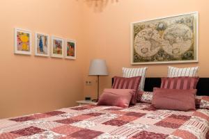 a bedroom with a bed with a blanket and pictures on the wall at BIT-City Studio und Appartement in Bitburg