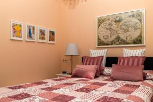 1 dormitorio con 1 cama con manta y cuadros en la pared en BIT-City Studio und Appartement, en Bitburg