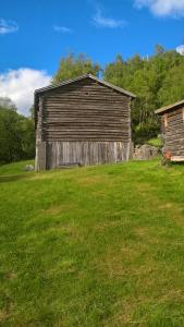 een oude houten schuur in een grasveld bij Brekkøye i Lom in Lom