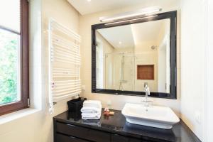 ein Bad mit einem Waschbecken und einem Spiegel in der Unterkunft Studio with terrace in a luxury closed estate by Grand Apartments in Sopot
