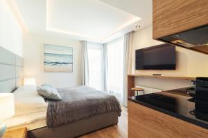 a hotel room with a bed and a flat screen tv at Studio with terrace in a luxury closed estate by Grand Apartments in Sopot