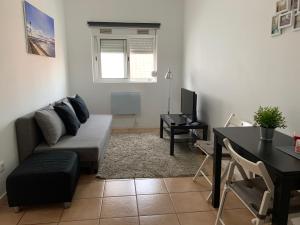 a living room with a couch and a table at TangoSierraResidences in Alcochete