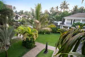 a view of a yard with palm trees and a house at Andores Resort And Spa - Calangute in Calangute