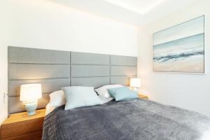 ein Schlafzimmer mit einem großen Bett mit zwei Lampen in der Unterkunft Studio with terrace in a luxury closed estate by Grand Apartments in Sopot