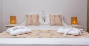 1 dormitorio con 2 toallas en una cama con 2 lámparas en Sun and Moon Villas en Aliko Beach