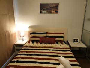- une chambre avec un lit et une couverture rayée dans l'établissement The Relaxing Room Mountain View at Baan Tew Lom Condominium Cha Am - Hua Hin, à Cha Am