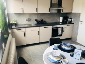 a kitchen with a table and a sink and a stove at Boardinghouse BeOne in Villingen-Schwenningen