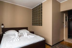 a bedroom with a bed with white towels on it at Gościniec Exclusive in Warsaw