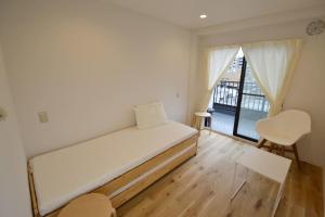 東京にあるEnzo Tokyoのベッドと窓が備わる小さな客室です。