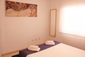 ein Schlafzimmer mit einem Bett mit zwei Handtüchern darauf in der Unterkunft Perfecto apartamento de playa in Callao Salvaje + 22 Fotos